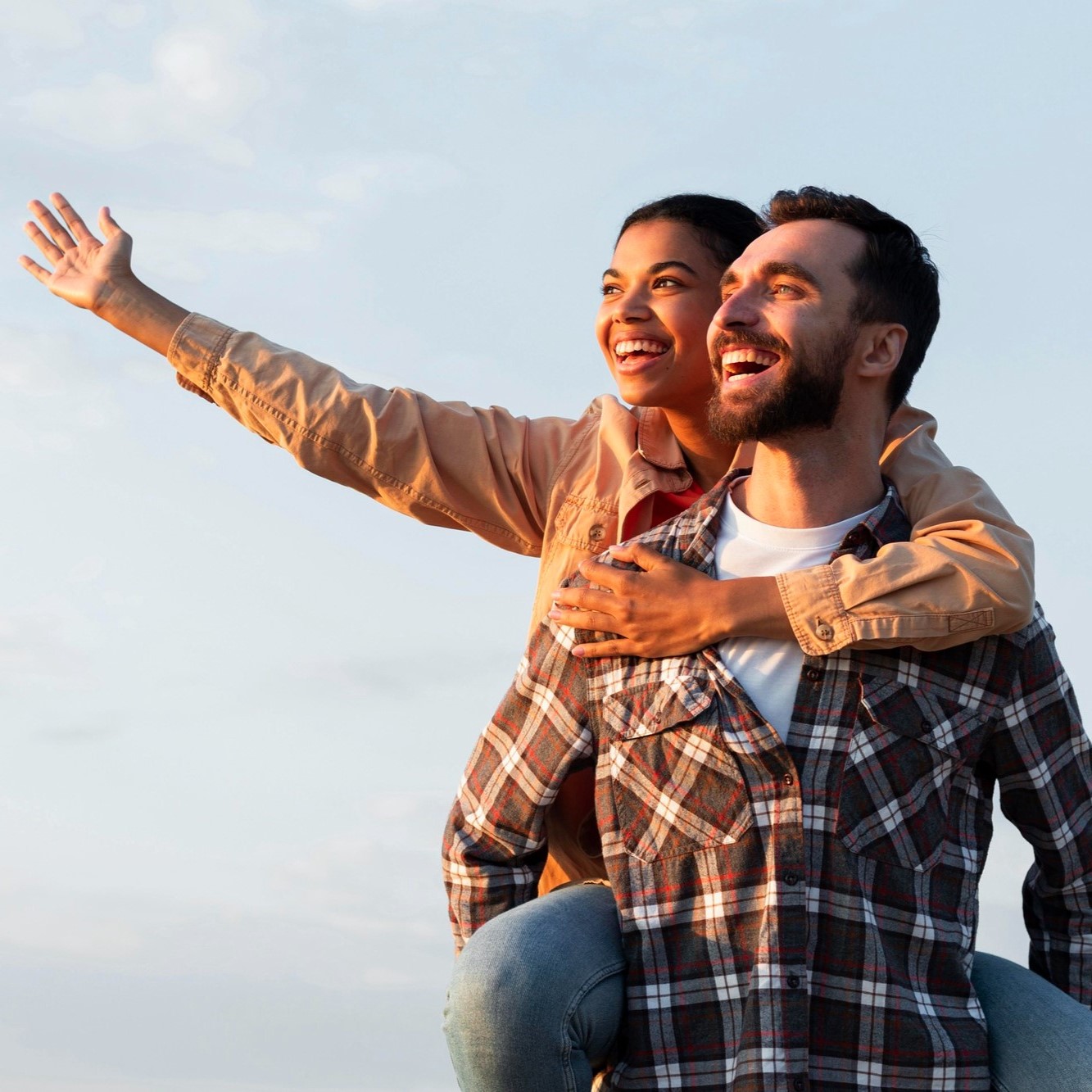 Laughing friends sharing a piggyback ride outdoors